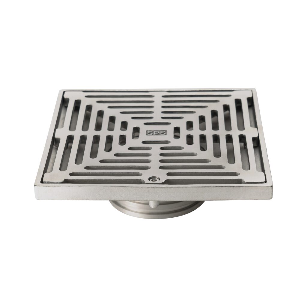 A stainless steel square floor drain with a grid pattern cover, featuring a central screw and the letters "SPS" engraved in the middle.